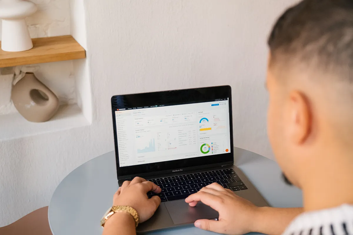 Team member reviewing SEO analytics dashboard on laptop at small table