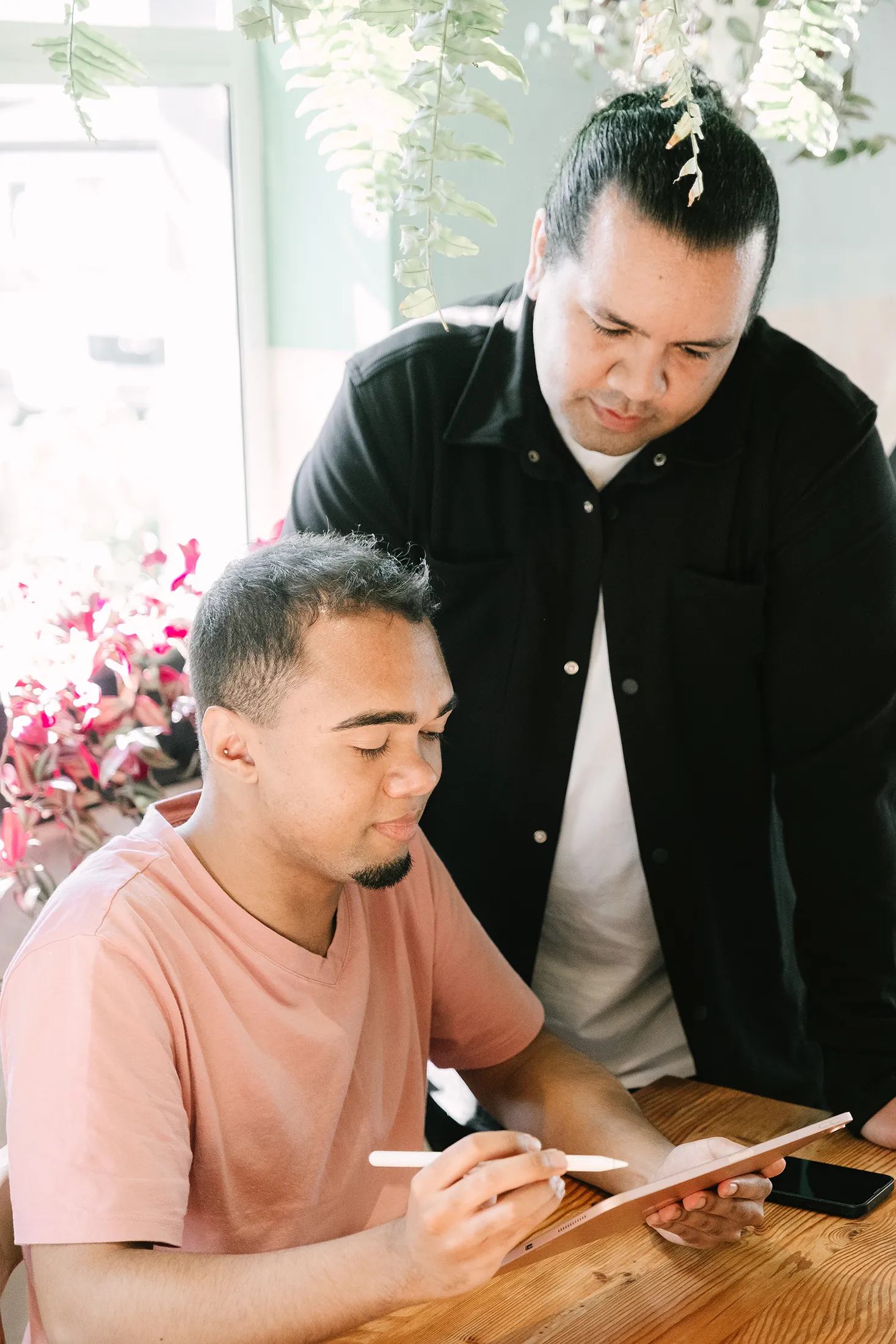 Creative team collaborating on brand identity design and visual strategy using a tablet during a branding session.